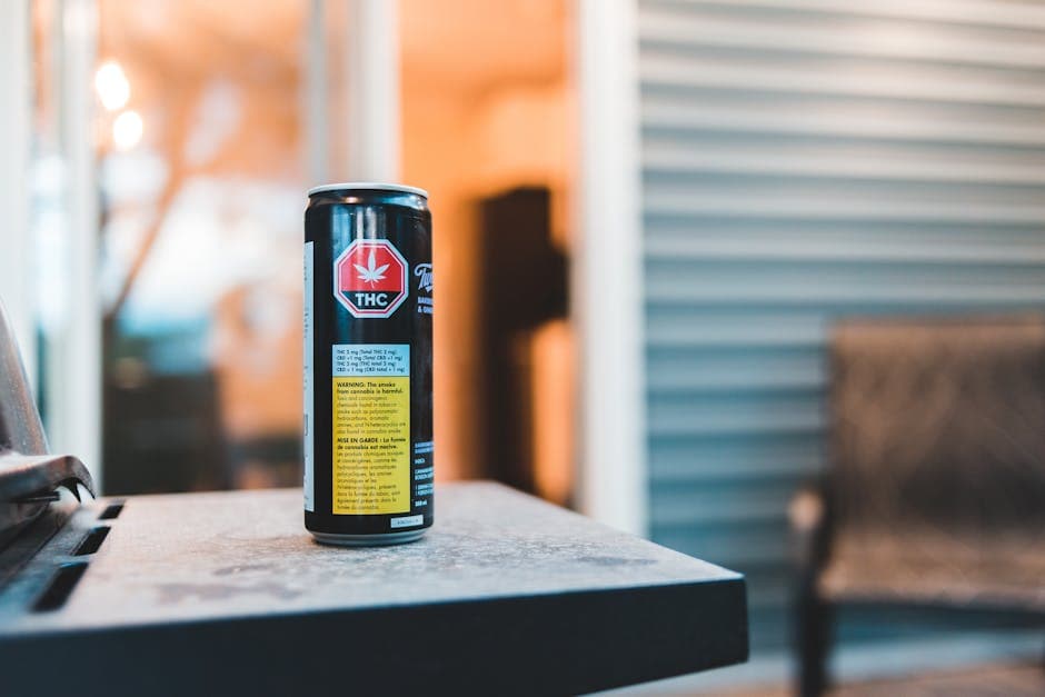 Colorful can of cannabis drink with text and image on shiny surface in building